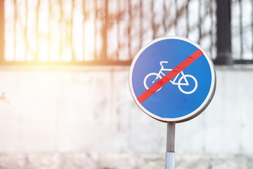 Road sign End of dedicated cycle path round blue sign with white bicycle symbol and red line strike through against