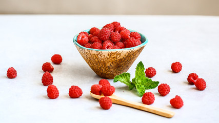 Ripe sweet raspberries in bowl on table close-up. natural ripe organic berries, copy space