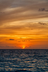 Fototapeta premium Vertical view of the sea horizon with deep blue waters and oranges colors sunset in Maldives
