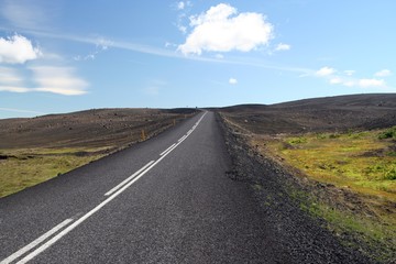 Endless straight asphalt road in barren wide landscape