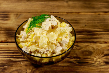 Festive salad with chicken breast, sweet corn, canned pineapple, cheese and mayonnaise on wooden table