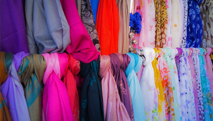 Fototapeta premium A variety of colorful fashion scarves for sale at a market