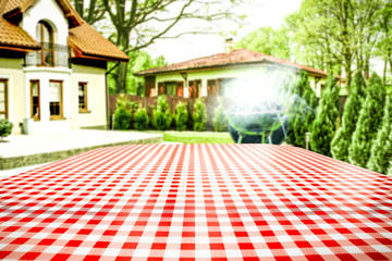White and red tablecloth and grill time in garden. 
