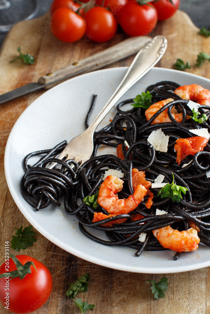 Wall mural Squid ink pasta with prawns and tomatoes