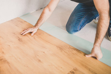 Adult man lays the laminate panel on the substrate with the technology