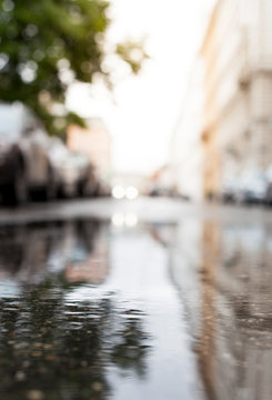 Regetropfen in Wasserpfütze auf Straße. Raindrops in water puddle on the road.