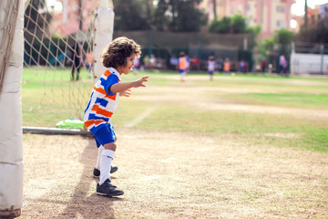 Obraz premium Little boy plays football outdoor. Children and lifestyle concept