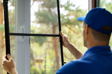 man installing insect mesh screen to protect room from mosquito