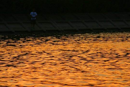 夕日が照らす川面と堰