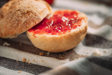 Sliced bread with strawberry jam on a tablecloth