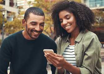 Smiling young couple looking at smartphone