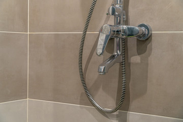 Beautiful shower mixer with traces of droplets and lime in bathroom of porcelain stoneware. Gray...