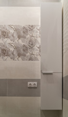 White wall bathroom cabinet. Porcelain stoneware on the walls. Gray shades