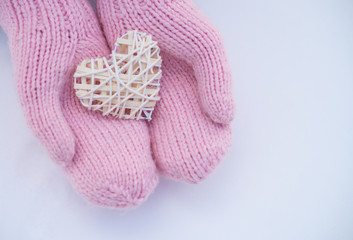 Female hands in mittens with heart, close-up