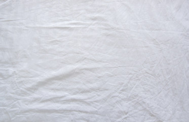 Fototapeta na wymiar Top view of wrinkles on an unmade bed sheet after waking up in the morning.