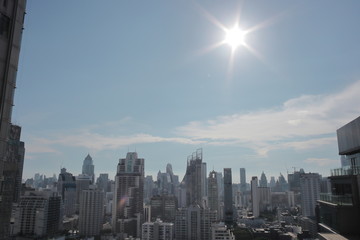 Fototapeta premium タイ バンコク 猛暑 ビル 都会のビル 強烈な太陽 逆光 オフィス 暑すぎる夏 照りつける ビル群 ビルディング 都市 シティー 