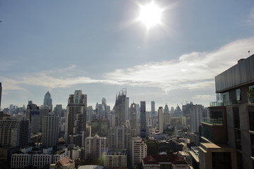 Fototapeta na wymiar タイ　バンコク　猛暑　ビル　都会のビル　強烈な太陽　逆光　オフィス　暑すぎる夏　照りつける　ビル群　ビルディング　都市　シティー　