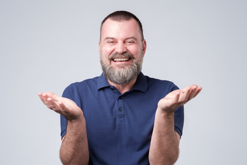 Man with beard in blue t-shirt laughing out loud, talking with friends, telling funny jok