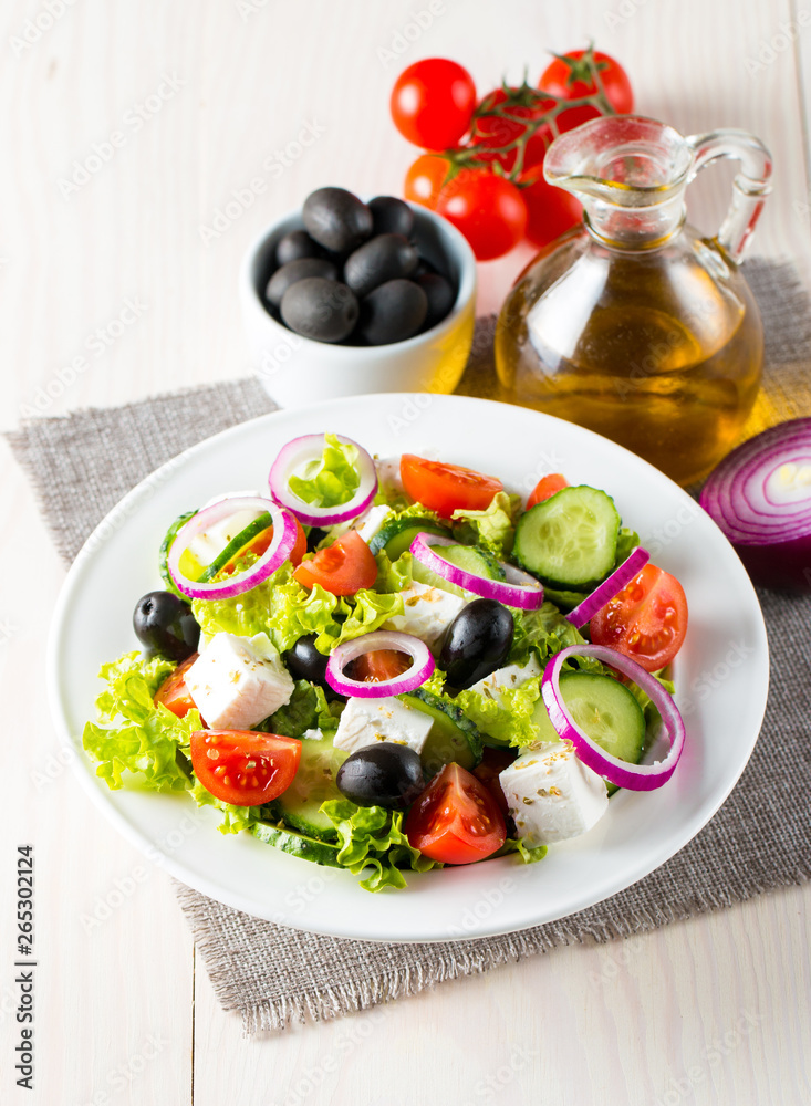 Wall mural fresh greek salad made of cherry tomato, ruccola, arugula, feta, olives, cucumbers, onion and spices