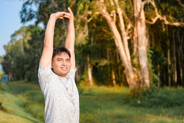 Young man stretching body after running at the park