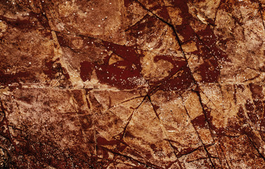 Rough texture of red stone with cracks and kinks close-up