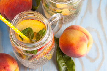 Homemade lemonade of ripe peaches and cold fresh mint. A jar of peach tea. Refreshing water.
