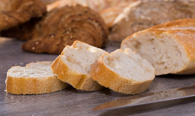 slices of wheaten bread and knife on wooden surface