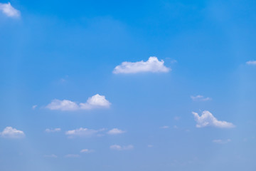 Fuffy clouds on bright blue sky background.