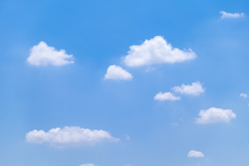 Naklejka na ściany i meble Fuffy clouds on bright blue sky background.