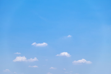 Fuffy clouds on bright blue sky background.