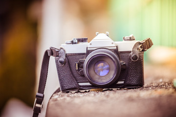 Retro vintage photography camera outdoors, stony wall