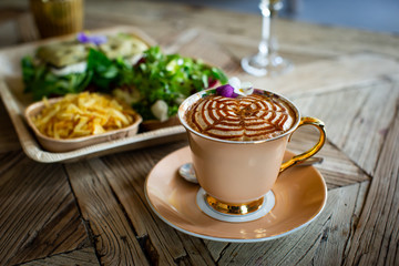 Capuccino with sweet on a Wood table