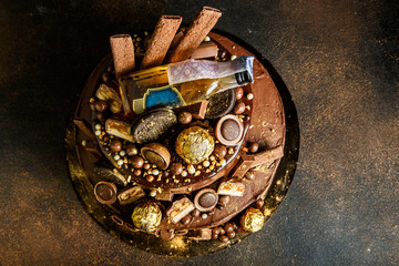 top view of delicious chocolate cake decorated with candies and cookies
