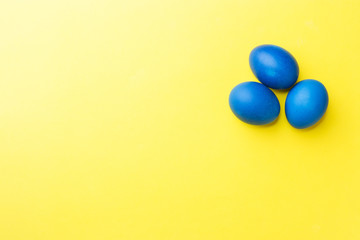 Colorful Easter eggs on yellow background. Copy space.