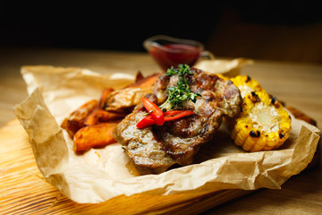 Pork steak with grilled corn and potatoes in creole