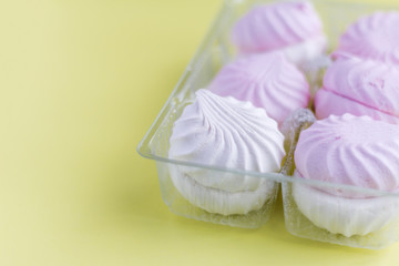 a delicious dessert, a delicate white and pink marshmallow on a yellow background