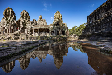 Fototapeta na wymiar Relections of the towers and beautiful face sculptures at the famous Bayon temple in the Angkor Thom temple complex, Siem Reap, Cambodia