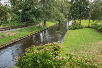 Fototapeta na wymiar Gardens and an idyllic canal in Giethoorn