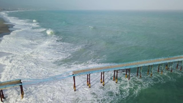 Pontile industriale sull' Oceano distrutto e crollato dalle onde tempestose.