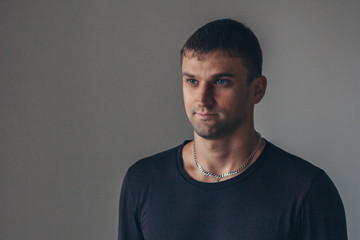 Obraz premium handsome man shows off gray clothes on grey background