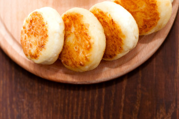 Cheese pancakes on a wooden board, horizontal format view from the top. For menu design and cafe advertising