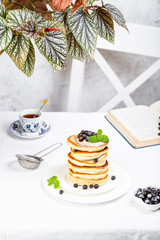 pancake stack decorated with blueberries and powdered sugar