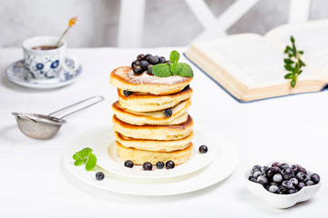 pancake stack decorated with blueberries and powdered sugar
