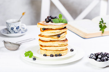 pancake stack decorated with blueberries and powdered sugar