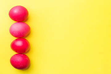 Colorful Easter eggs on yellow background. Copy space.