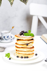pancake stack decorated with blueberries and powdered sugar