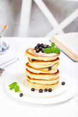 pancake stack decorated with blueberries and powdered sugar