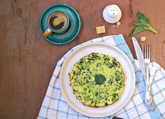 Breakfast, omelet with nettles on a white clay plate. Healthy food. Food from wild herbs. Top view, copy space.
