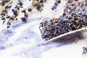 Spa and wellness setting with lavender flowers, sea salt, oil in a bottle, aroma candle on wooden white background