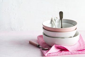 Empty pink and white bowls and kitchen utensils